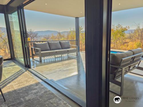 a screened in porch with a couch and a pool at 99 on Zwartkloof - Luxury Bushveld Retreat in Warmbaths