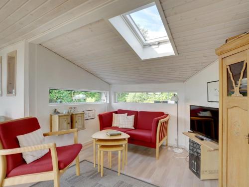 a living room with red furniture and a skylight at Holiday Home Arnette - 150m from the sea by Interhome in Sjølund