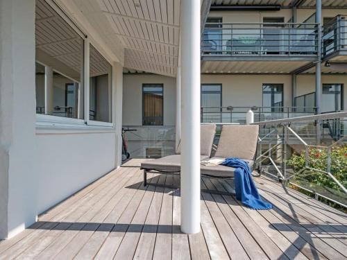 a chair sitting on a wooden deck on a building at Apartment Irma - 25m from the sea by Interhome in Tranekær