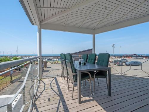 a table and chairs on a deck with a view of the ocean at Apartment Irma - 25m from the sea by Interhome in Tranekær