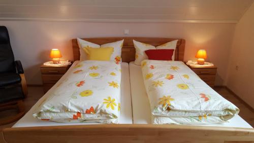 a bedroom with two beds with pillows and two lamps at Pension am Kurgarten in Bensersiel