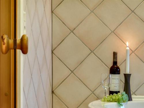 a candle and a bottle of wine and wine glasses at Holiday Home Henrijette - 200m from the sea by Interhome in Sjølund
