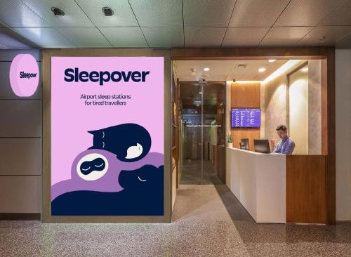 a man sitting at a desk in an office lobby at Sleepover Doha South Node - formerly sleep 'n fly in Doha
