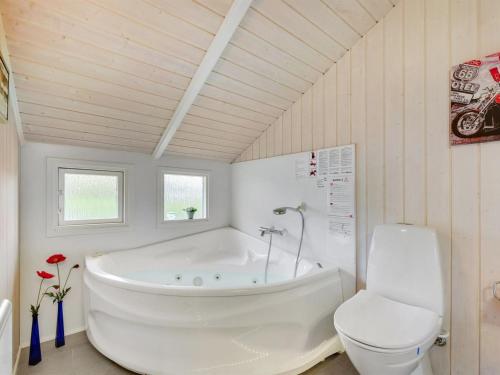 a bathroom with a white tub and a toilet at Holiday Home Hwiting - 200m from the sea by Interhome in Broager