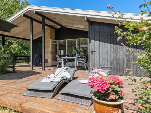 a patio with two chairs and a table on a deck at Holiday Home Hasti - 700m from the sea by Interhome in Tranekær
