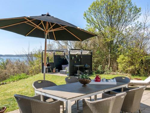 a picnic table with an umbrella and chairs at Holiday Home Ose - 50m from the sea by Interhome in Sønder Stenderup