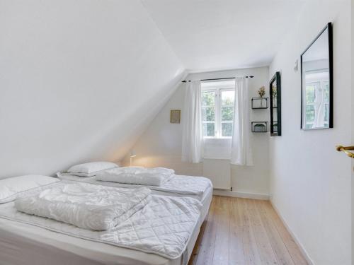 two beds in a white room with a window at Holiday Home Sirkku - 320m from the sea by Interhome in Tranekær