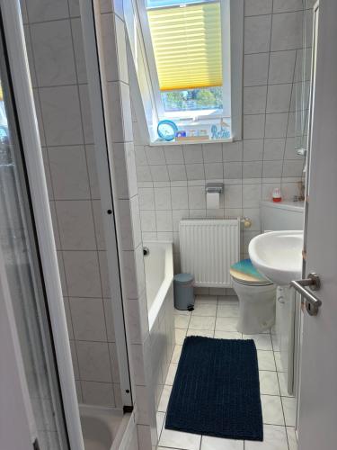 a bathroom with a sink and a toilet and a window at Haus Lönsweg in Bad Bevensen