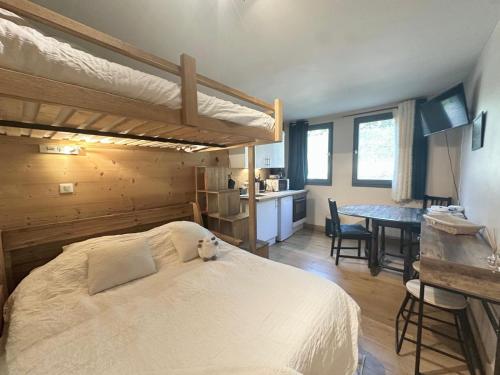 a bedroom with a bed and a kitchen with a table at Nouveau Refuge de l aiguille in Chamonix-Mont-Blanc