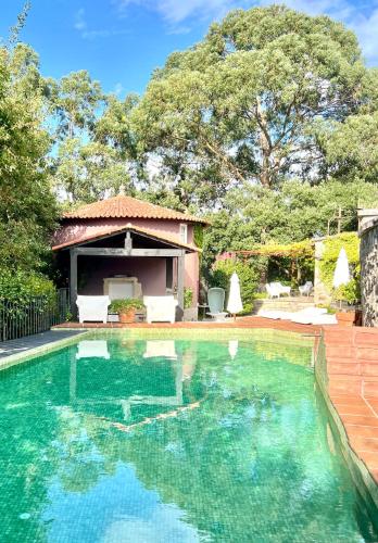 a swimming pool in front of a house at Enoturismo Novavila Rias Baixas Wine Design in Meis