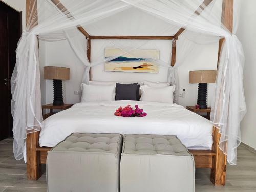 a bedroom with a white bed with a white canopy at Villa Solenzara - Private Luxury Residence Nosy Be in Nosy Be