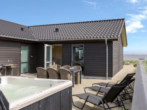 a hot tub on the patio of a house at Holiday Home Eino - 30m from the sea by Interhome in Sjølund