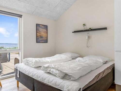 two beds in a room with a large window at Holiday Home Eino - 30m from the sea by Interhome in Sjølund