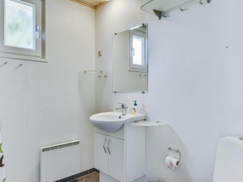 a white bathroom with a sink and a mirror at Holiday Home Leandra - 600m from the sea by Interhome in Augustenborg