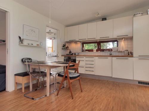 a kitchen with white cabinets and a table and chairs at Holiday Home Pirjo - 50m from the sea by Interhome in Haderslev