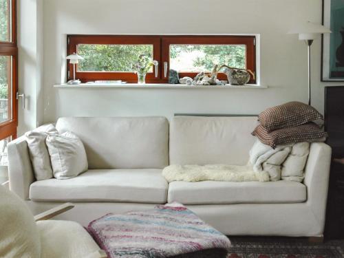 a living room with a white couch with a blanket at Holiday Home Pirjo - 50m from the sea by Interhome in Haderslev