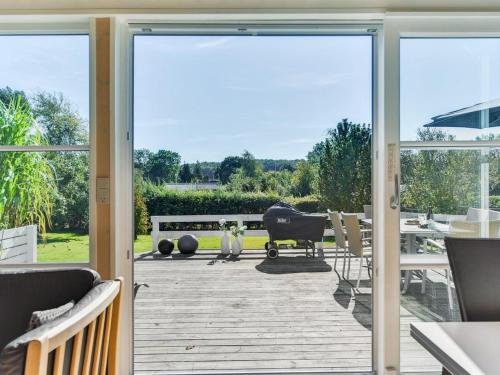 an open glass door to a patio with a grill at Holiday Home Leandra - 600m from the sea by Interhome in Augustenborg
