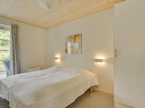 a bedroom with a white bed and a window at Holiday Home Fausta - 150m to the fjord by Interhome in Gråsten