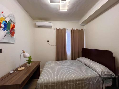a small bedroom with a bed and a desk at The Infinity View in Talisay