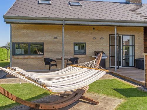 a hammock in front of a house at Holiday Home Hans - 700m from the sea by Interhome in Neder Lysabild