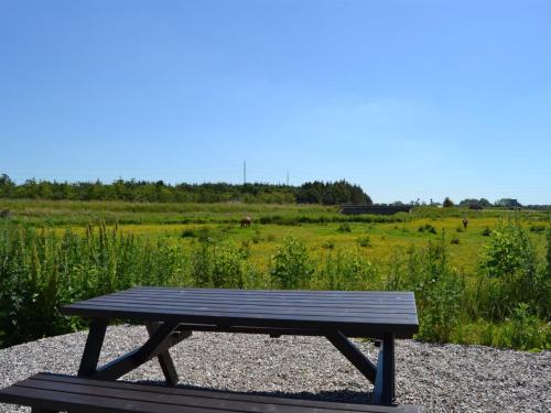 a wooden picnic table sitting on a gravel field at Apartment Esja - 22km from the sea by Interhome in Bredebro