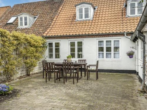 a table and chairs in front of a white house at Holiday Home Ajna - 9-8km from the sea by Interhome in Tønder