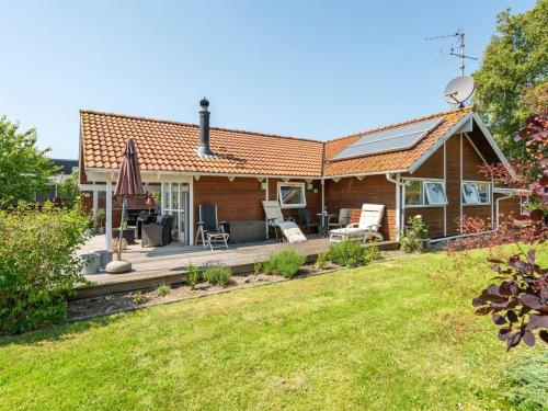 a house with a deck and a yard at Holiday Home Kaike - 100m from the sea by Interhome in Haderslev