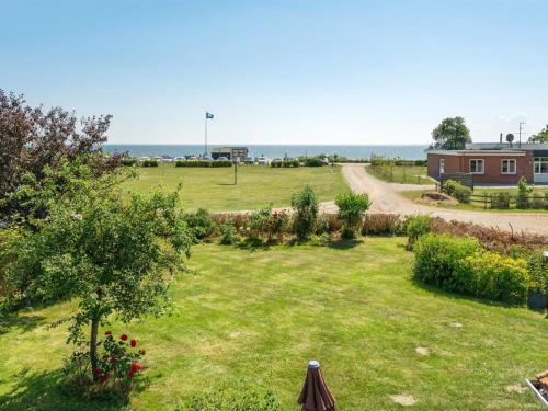 a view of a yard with a house and the ocean at Holiday Home Kaike - 100m from the sea by Interhome in Haderslev
