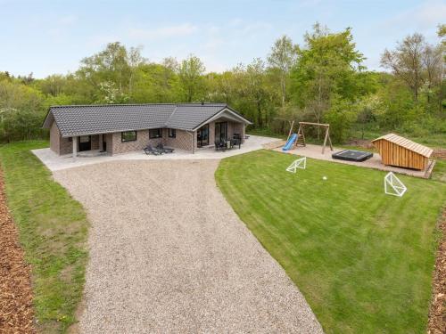 a backyard with a house and a playground at Holiday Home Eylar - 28km from the sea by Interhome in Toftlund