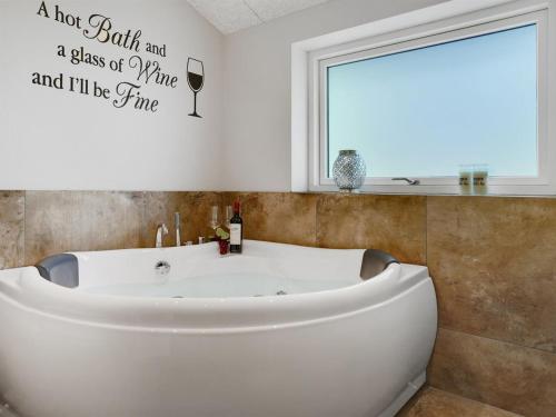 a bathroom with a tub and a glass of wine and ill be fine at Holiday Home Eylar - 28km from the sea by Interhome in Toftlund