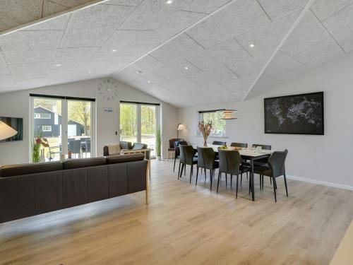 a dining room and living room with a table and chairs at Holiday Home Eylar - 28km from the sea by Interhome in Toftlund