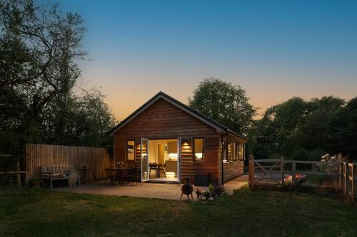 a small cabin with two dogs in a yard at Lakeside Lodge in Eastleigh
