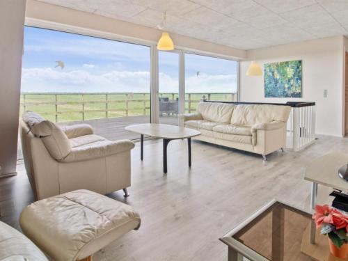 a living room with a couch and chairs and a table at Holiday Home Ammy - 7-5km from the sea by Interhome in Højer