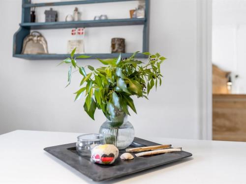 a vase with a plant on a tray on a table at Holiday Home Elma - 24km from the sea by Interhome in Højer