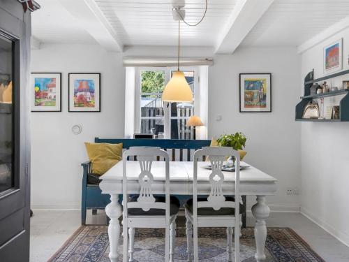 a dining room with a white table and chairs at Holiday Home Elma - 24km from the sea by Interhome in Højer