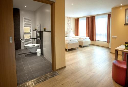 a hotel room with a bed and a bathroom at Haus Hubertus in Winterspelt