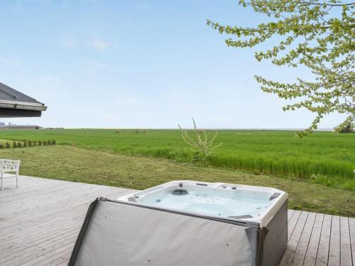 a hot tub sitting on a patio next to a field at Holiday Home Ajla by Interhome in Bredebro