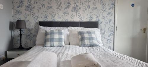 a bedroom with a white bed with blue and white wallpaper at Studio No5, Cockermouth The Lakes in Cockermouth