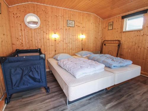 a bedroom with two beds in a wooden wall at Holiday Home Edy - 25km from the sea by Interhome in Toftlund