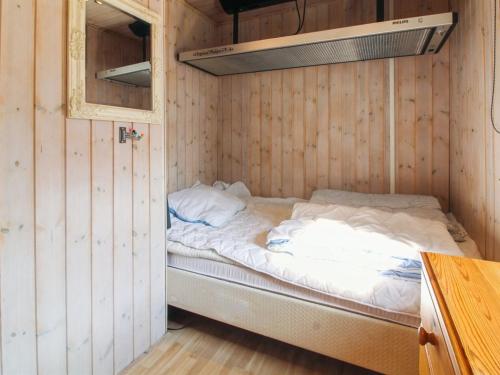 a small room with a bed in a wooden wall at Holiday Home Edy - 25km from the sea by Interhome in Toftlund