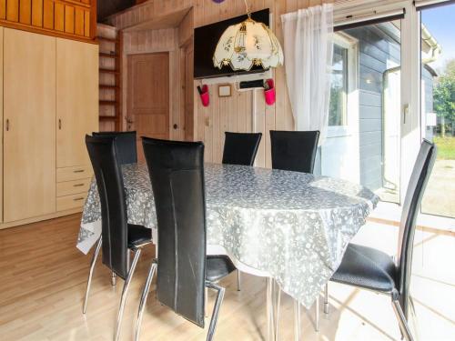 a dining room with a table and black chairs at Holiday Home Edy - 25km from the sea by Interhome in Toftlund