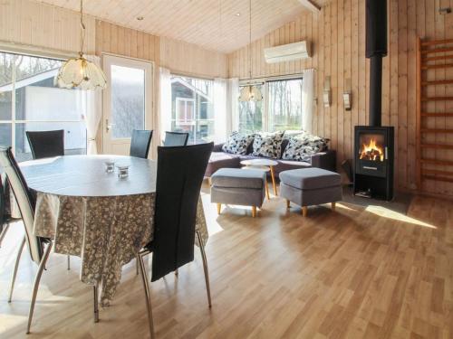 a living room with a table and a fireplace at Holiday Home Edy - 25km from the sea by Interhome in Toftlund