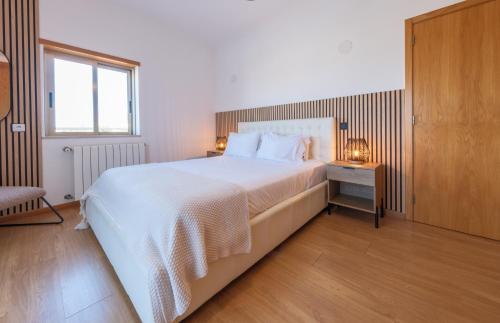 Villa Ofelia 46 by Destination Algarve في Santo Amaro: غرفة نوم بها سرير أبيض كبير ونافذة