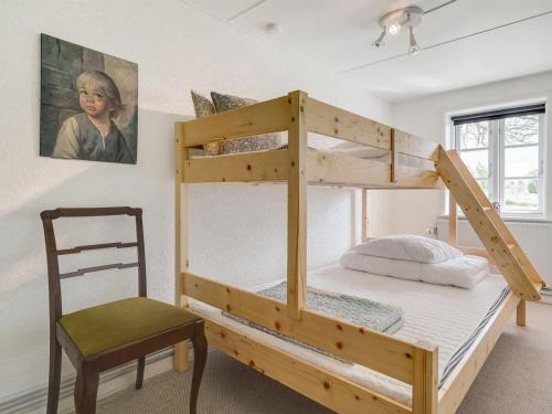 a bunk bed with a chair in a room at Holiday Home Inda - 10km from the sea by Interhome in Højer