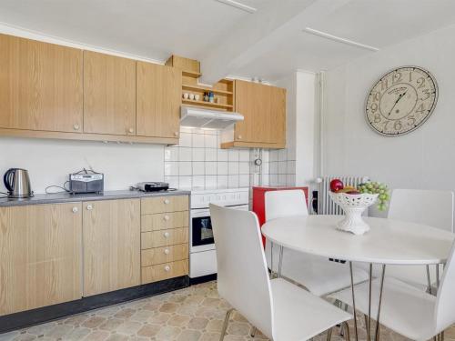 a kitchen with a table and a clock on the wall at Holiday Home Inda - 10km from the sea by Interhome in Højer