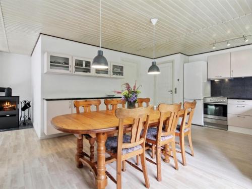 a kitchen and dining room with a wooden table and chairs at Holiday Home Florinka - 31km from the sea by Interhome in Toftlund