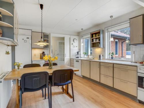 a kitchen with a wooden table and some chairs at Holiday Home Birita - 20km from the sea by Interhome in Ribe