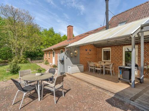a patio with a table and chairs on a wooden deck at Holiday Home Birita - 20km from the sea by Interhome in Ribe