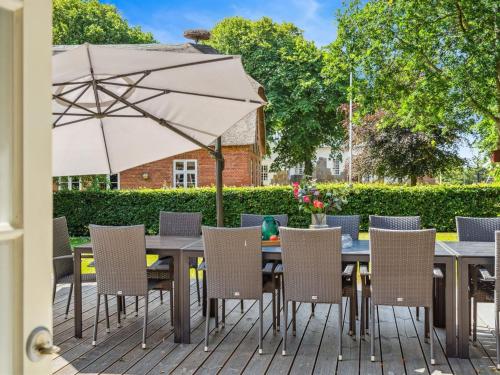 a table with chairs and an umbrella on a patio at Holiday Home Thordis by Interhome in Højer