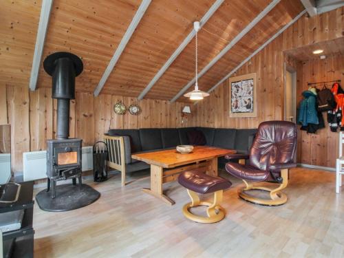a living room with a couch and a wood stove at Holiday Home Carlotta - 12km from the sea by Interhome in Oksbøl